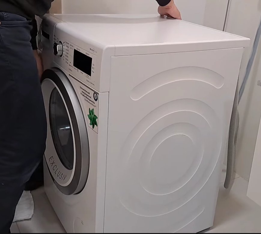 Bosch dishwasher being pulled forward from under kitchen counter to tilt and drain the base tray for E15 error fix