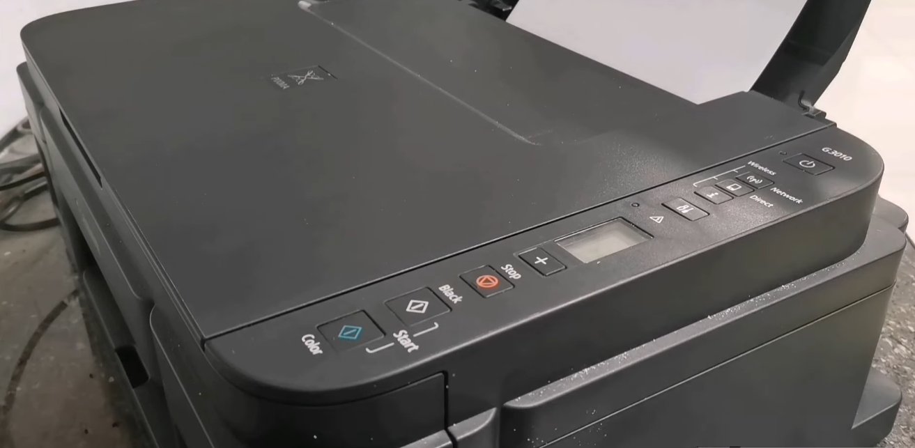 Canon Pixma G3010 control panel showing Color Start, Black Start, Stop and navigation buttons on the top surface along with the small LCD display and wireless indicator lights