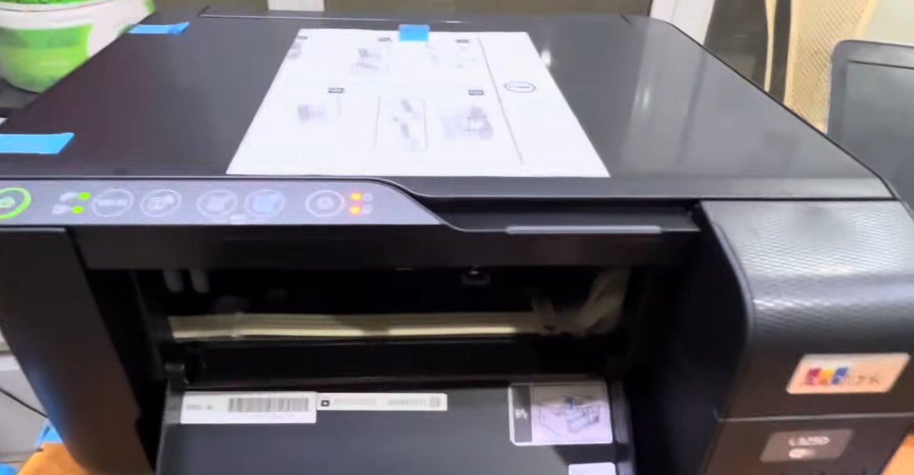 Epson L350 EcoTank printer with paper output tray open showing the internal paper path and roller mechanism visible from the front while both orange error indicator lights are lit on the control panel