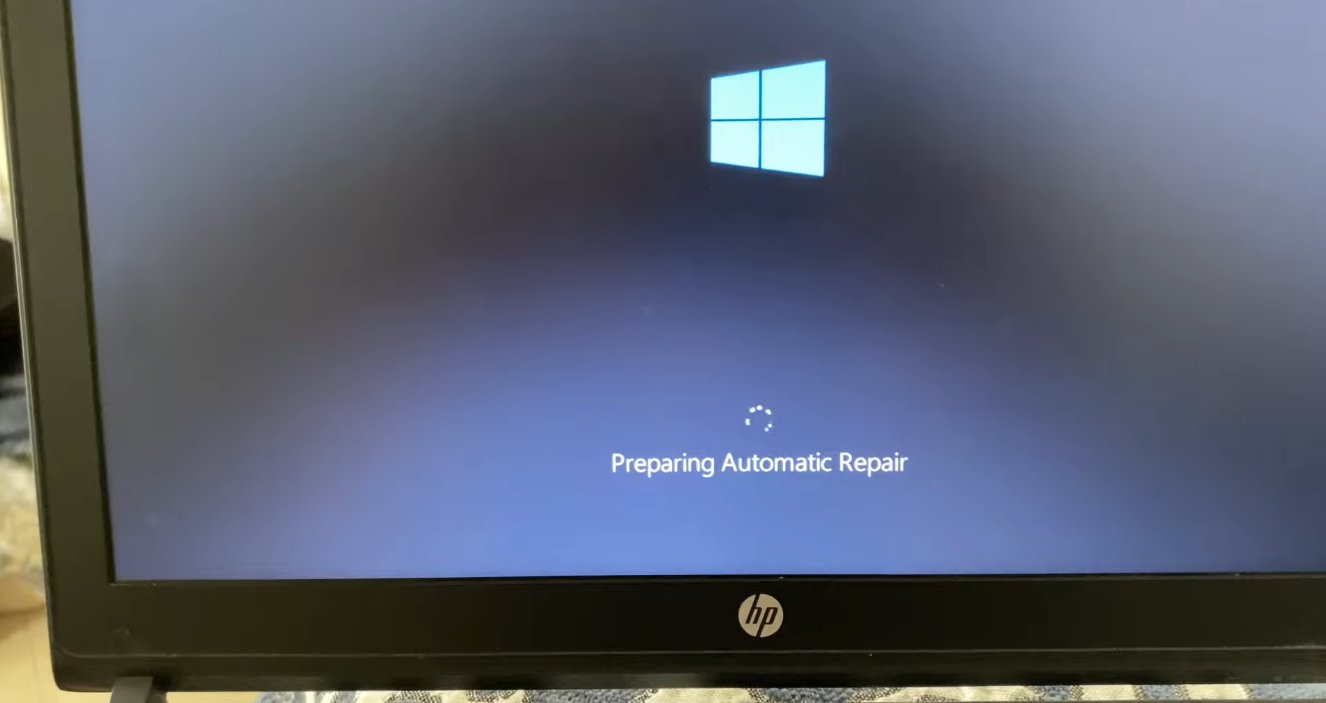 Windows laptop screen showing 'Preparing Automatic Repair' message with spinning dots circle under the Windows logo on a dark blue background