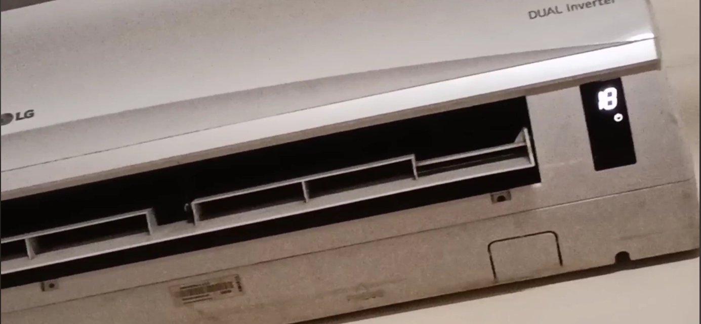 LG Dual Inverter AC indoor unit with panel open showing internal components and display blinking, indicating an error condition