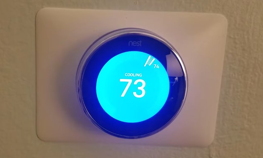 Google Nest thermostat mounted on wall showing blue Cooling active display with temperature set to 73 degrees indicating successful E73 fix and cooling system working normally