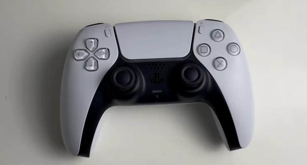 Sony PS5 DualSense controller front view on white surface showing both black analogue thumbsticks D-pad face buttons touchpad and PlayStation logo with the typical drift-prone stick layout clearly visible