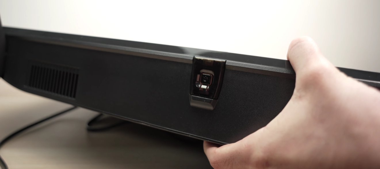 Close-up of Samsung TV bottom edge showing the physical power button location and a hand pressing it during the 30-second power drain reset procedure