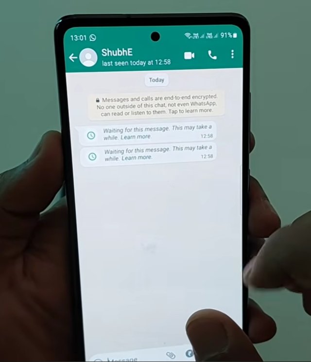 Android phone showing WhatsApp chat with the contact ShubhE where two message bubbles both display Waiting for this message This may take a while Learn more with clock icons confirming the decryption failure error state