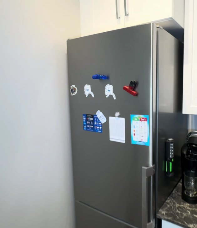 Stainless steel Whirlpool refrigerator in kitchen showing full exterior with fridge door and bottom freezer drawer