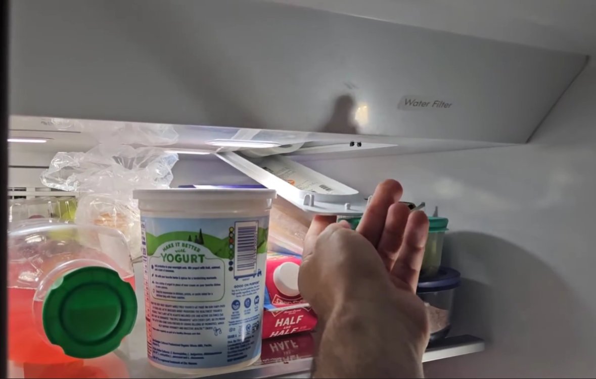 Inside of Whirlpool fridge showing food containers and items on shelves near the door that could prevent proper door sealing and cause beeping