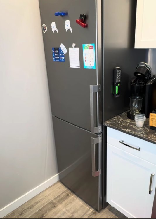 Side view of Whirlpool refrigerator with bottom freezer showing full door alignment and handle position for checking hinge level